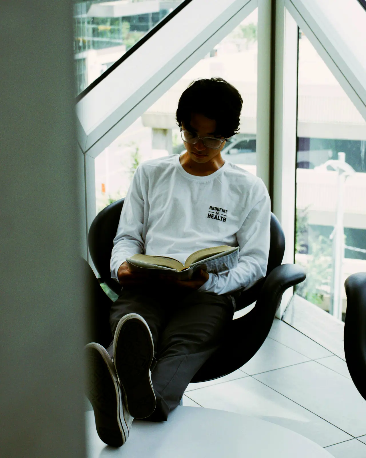 Someone reading in a chair by the window